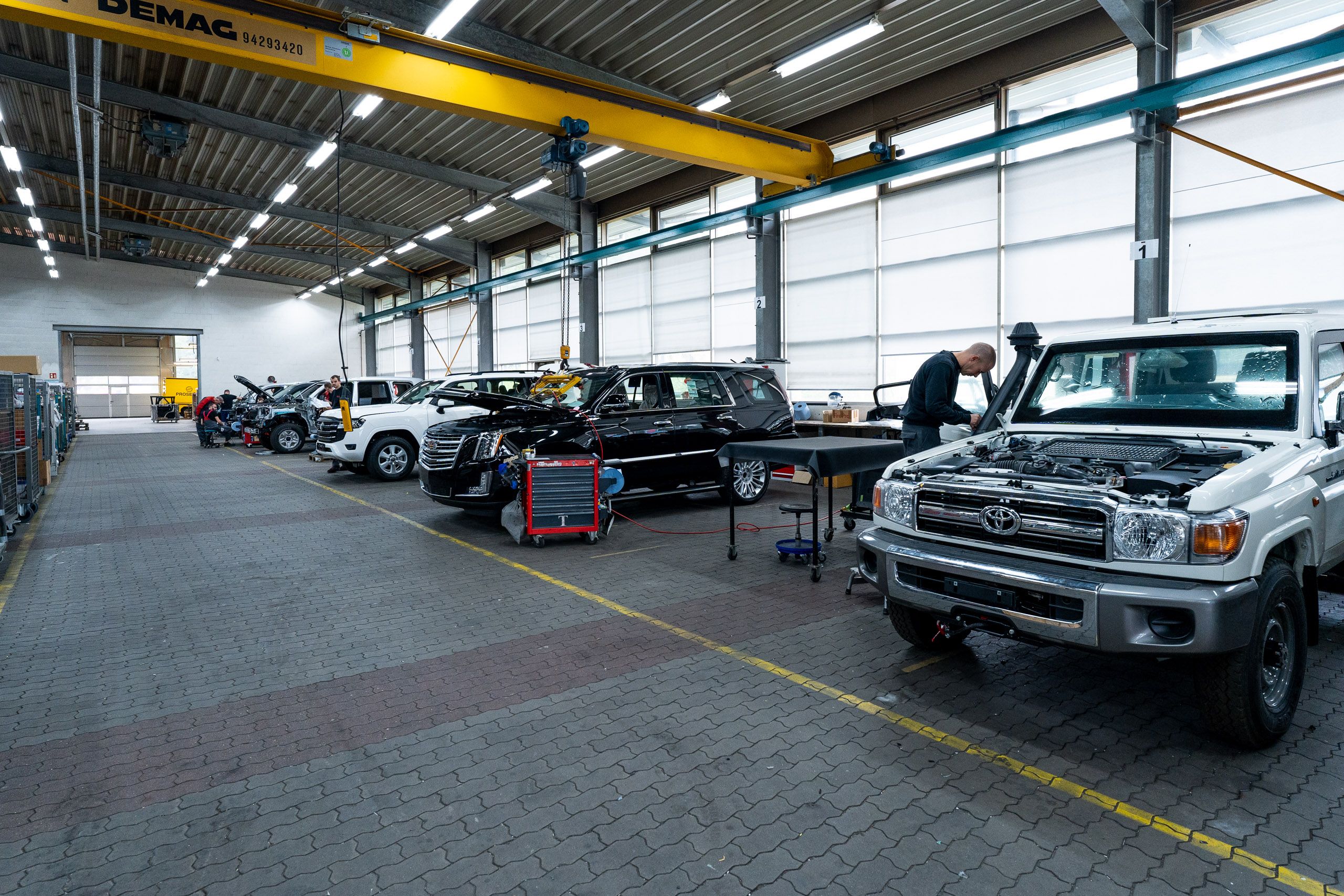 Eine große STOOF-Werkshalle mit mehreren Fahrzeugen